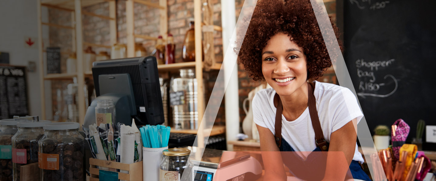 Woman Smiles Behind the Register at Her Coffee Bar